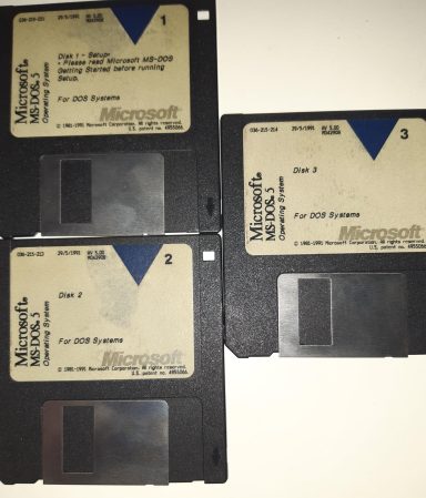 Drei alte Disketten mit Microsoft-Labels und handschriftlichen Zahlen.